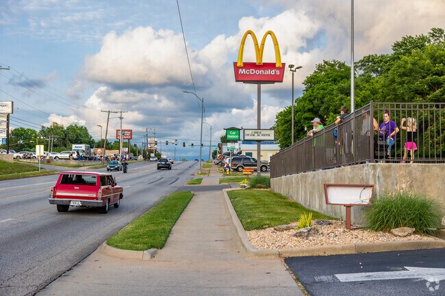 A classic car cruises along Kearney Street as onlookers watch.