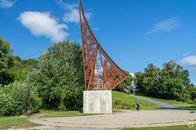 A person checks out a large bronze sculpture near Maple Ave District.