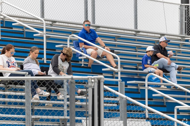 Excited fans in the bleachers cheer on players at a high school baseball game in Mont Belvieu.