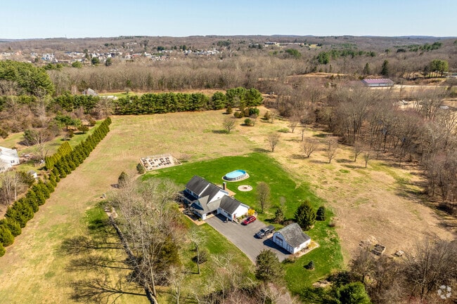 A home in Lisbon sits on a large plot of land with large yard sectioned off by small trees.