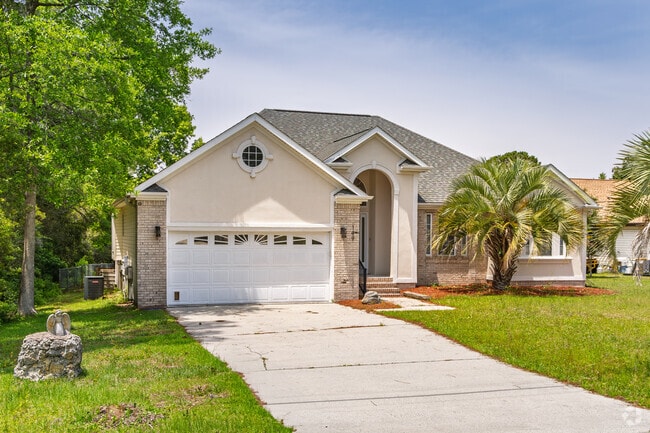 A charming stucco home in Boiling Spring Lakes features tropical landscaping and privacy.