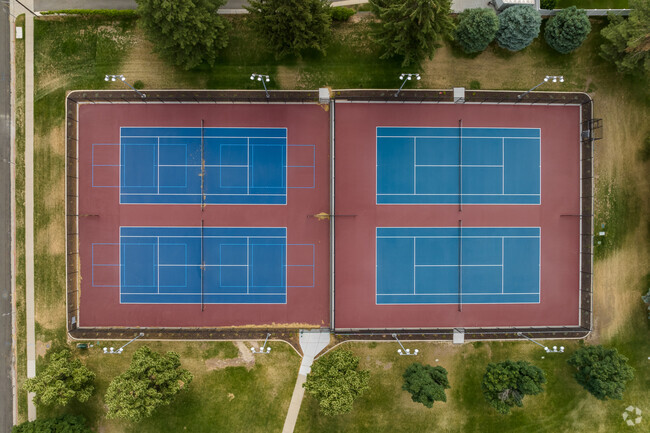 Blue and red tennis courts surrounded by green lawns at Ridgecrest Elementary School.