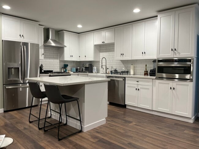 Full-size open kitchen with premium stainless appliances and quartz counters and island.