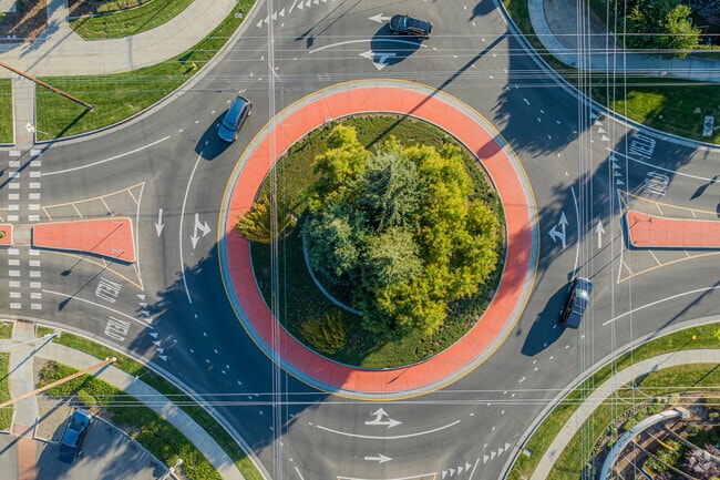 Cars wrap around this Village One round-a-bout.