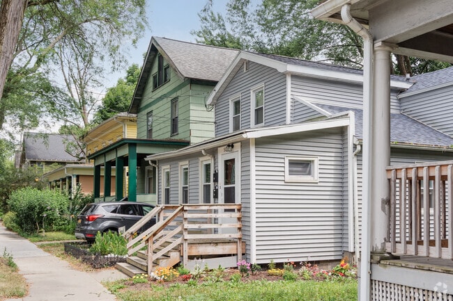 A bungalow style house sits on a tightly packed street in Downtown Ithaca.