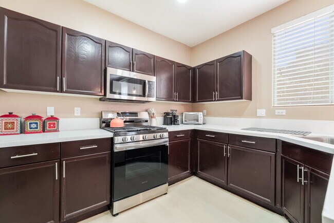 Kitchen featuring stainless steel appliances and dark brown cabinetry