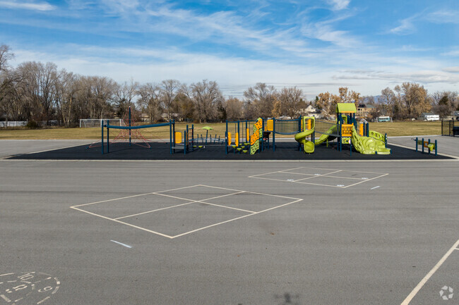 A large playground at Midvalley Elementary School is situated on soft turf.