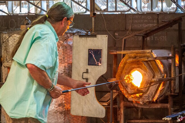 An artist heats glass in a kiln at Tesuqueu Glassworks.