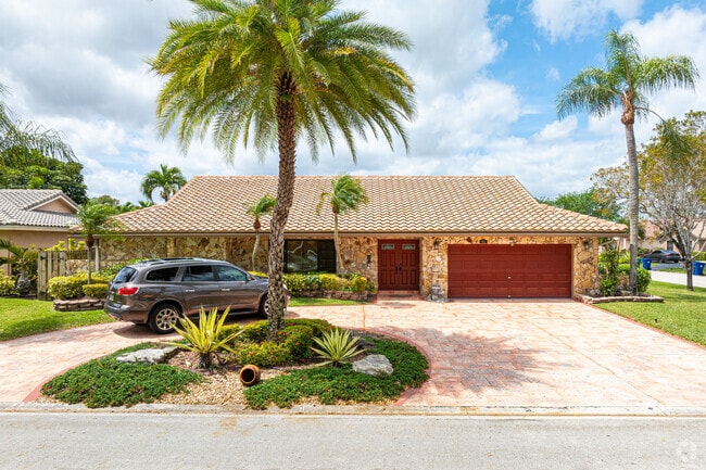 This is a Ranch-style house featuring a stone veneer facade, located in Cypress Glen.
