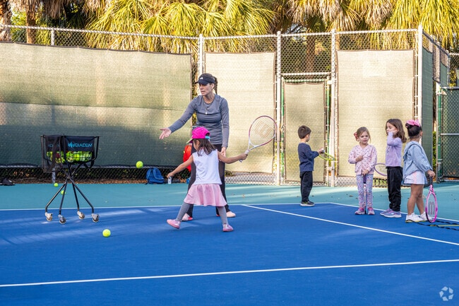Kids enjoying tennis classes at Emerald Estates Park near Green Meadows.