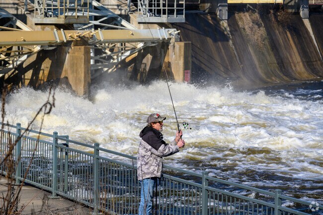 A man fishes at the Moores Park Dam in Lansing.