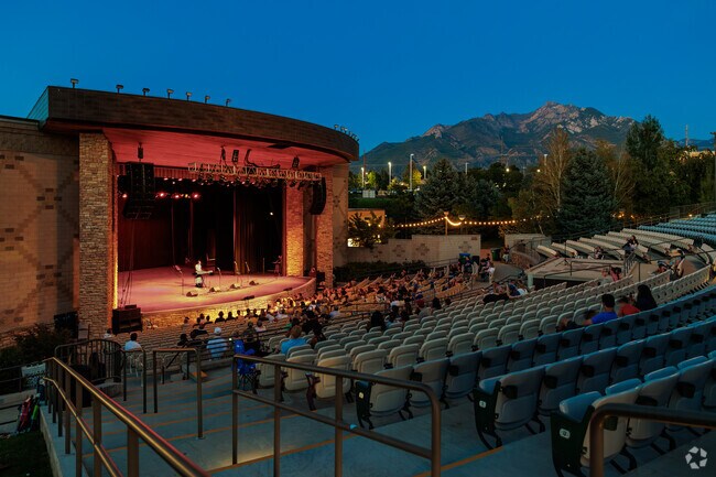 The blue sky at dusk contrasts with glowing red and yellow lights at Sandy Amphitheater.