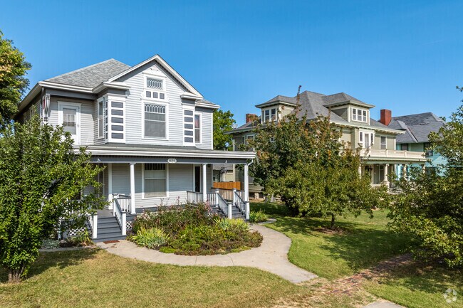Colonial style homes are flanked by brick sidewalks and roads near Downtown Topeka.