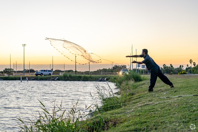 A Harlingen resident uses a trawl net to catch fish at Dixieland Park.