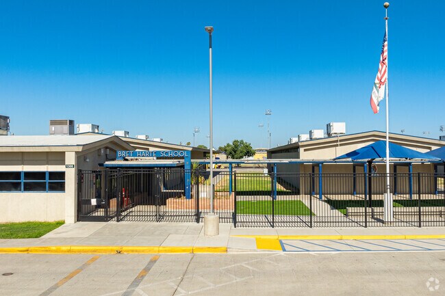 An American flag waves above the entrance to Bret Harte Elementary School.