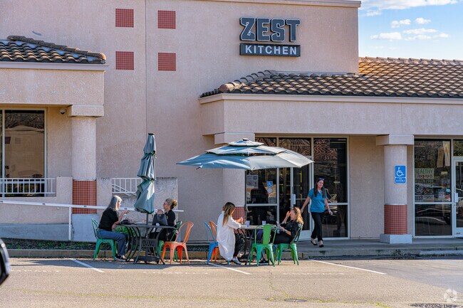 Ladies gather and chat front of Zest Kitchen in Sunset Whitney neighborhood.