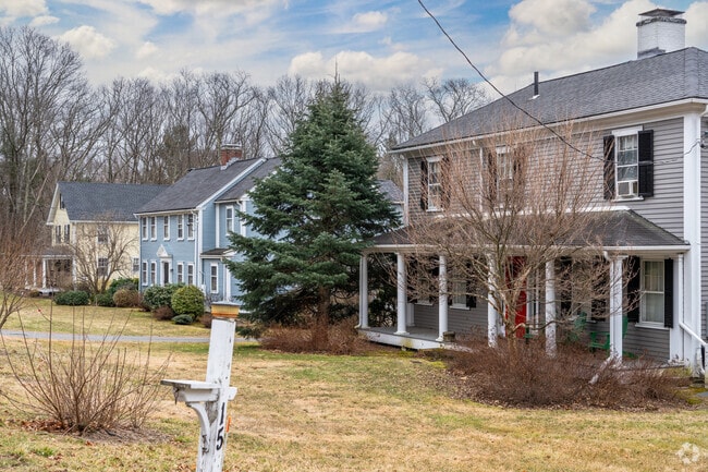 Colonial-style homes in Lincoln have large lawns and green shrubbery.