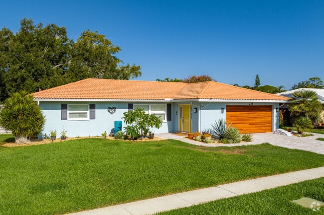 This stunning ranch style home has a wood finish garage door in Gulf Gate Estates.