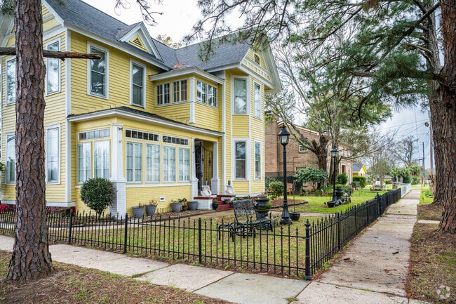 This yellow home with wood siding in Texas Street features a wrought-iron fence.