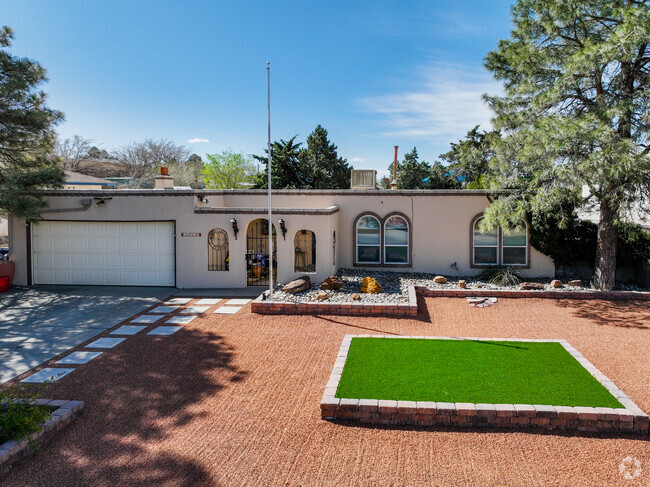 A tan stucco adobe home in Onate with brick accents.