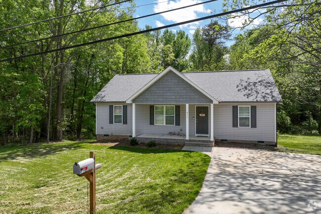 You will find many houses like this charming ranch-style home with a welcoming front porch nestled amongst lush green trees in the Madison neighborhood.