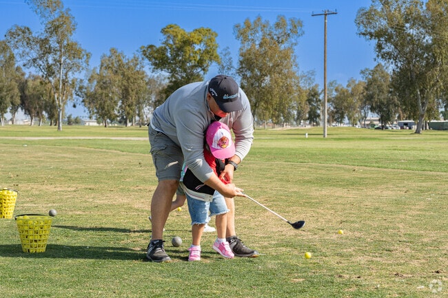A Tulare father takes time to show his daughter how to tee off at Tulare Golf Course.