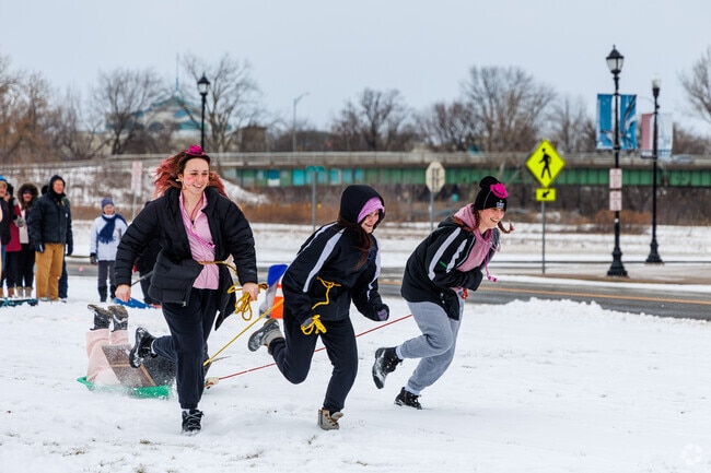 Competitors race in the human dog sled games at Winterfest 2024 near Northside Syracuse.