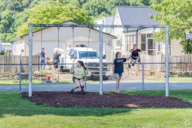 Friends gather for fun on the swings at Acme Park in Harmar Township.
