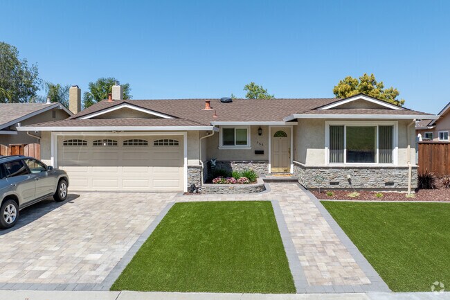 This updated Midcentury Ranch in Hidden Glen South features stone accents and a paver driveway.