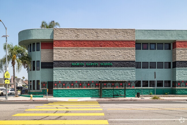 The bright green Marcus Garvey School sign is shown on the side of the building in Los Angeles.