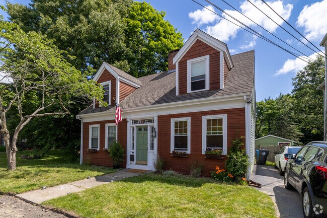 This restored Cape Cod in Whitman shows shows the beautiful contrast of red and green.
