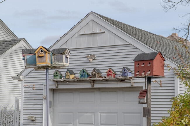 A colorful array of bird houses by the garage of this Acushnet neighborhood home are inviting.