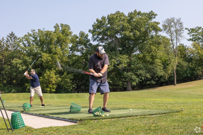 The Indian Trails Golf Course has a large driving range teaming with practicing golfers.