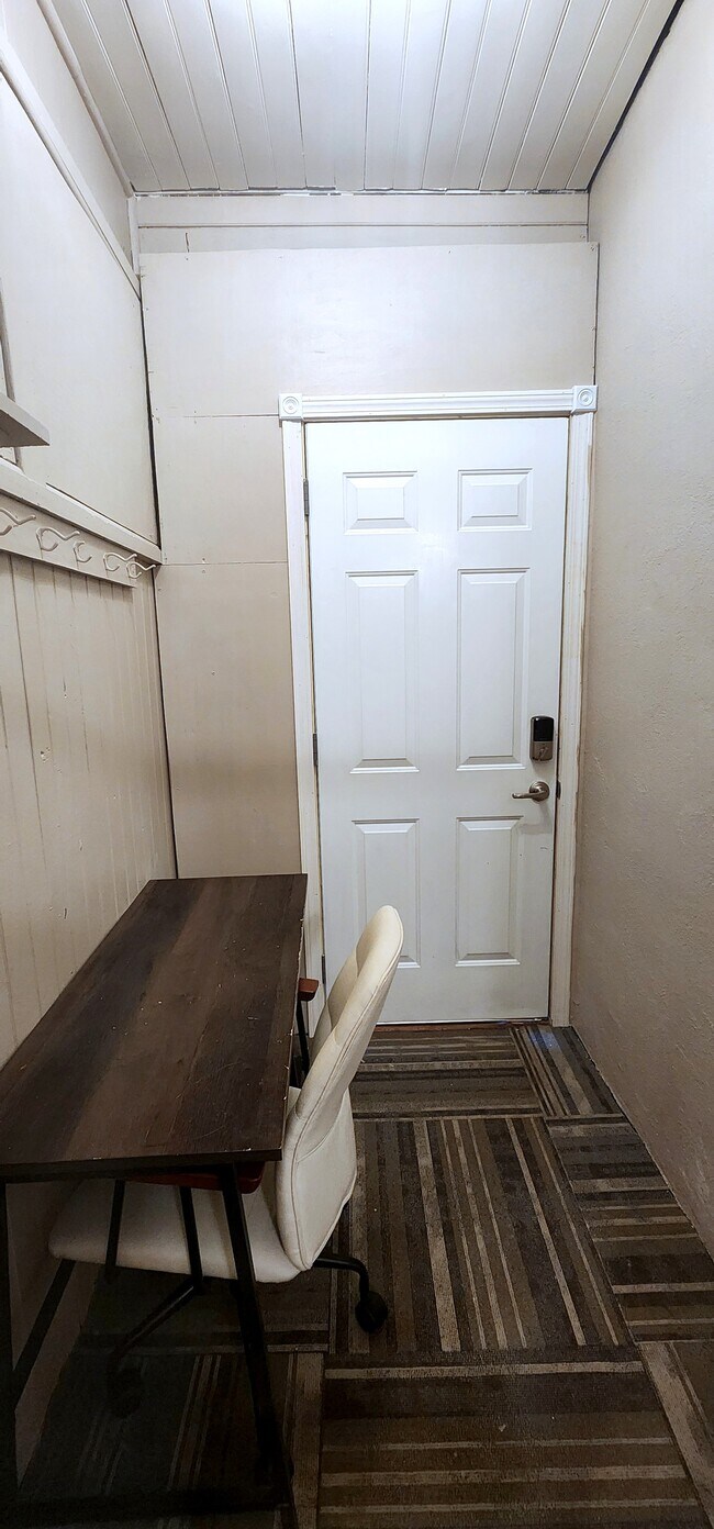 Dedicated desk and chair for remote work near the private back entrance.