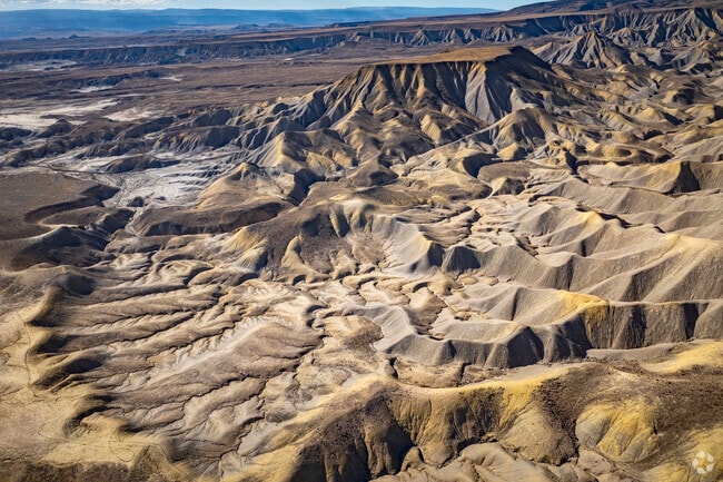 The Adobe Badlands in Delta, Colorado, create a stunning backdrop with their rugged clay hills, winding gullies, and dramatic flat tops. Shaped by time, this unique topography adds to the town’s scenic beauty, offering breathtaking views and a glimpse into the region’s rich geological history.