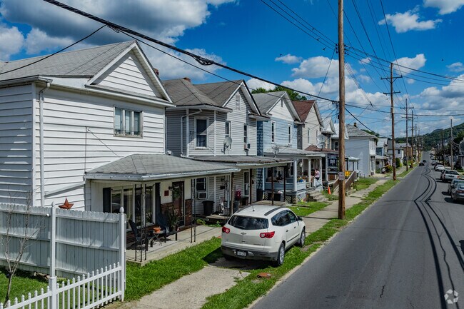 Two story single family homes sit close to the road with sidewalks on some streets of Keyser.