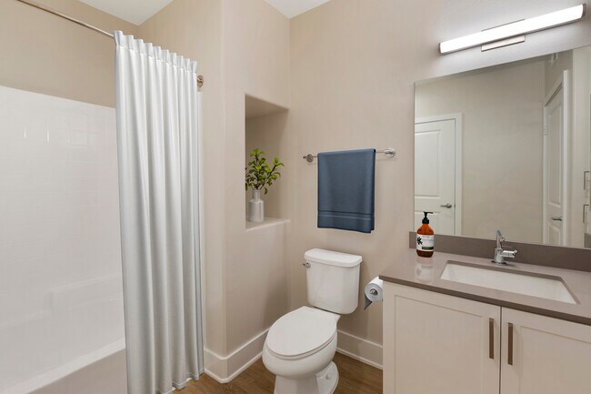 Renovated Package I bath with grey quartz countertops, white cabinetry, and hard surface flooring