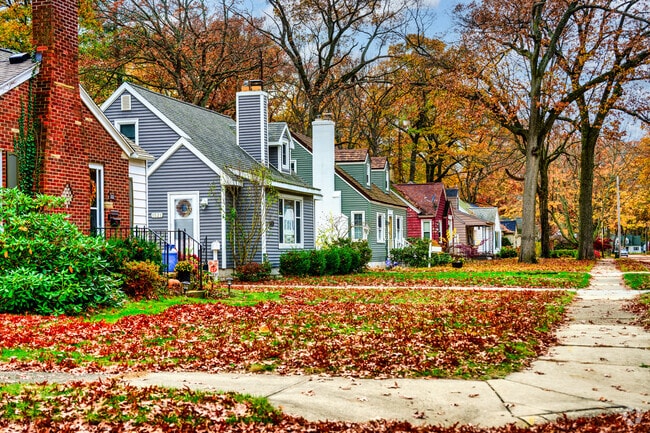 A row of Cape Cod homes lines a street filled with mature trees in Muskegon.