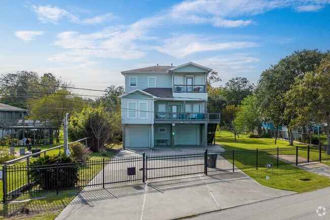 Three-story homes rise behind gated yards in Bacliff.