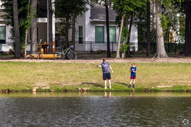 A father and son fish on the water's edge on the lake at The Highlands.