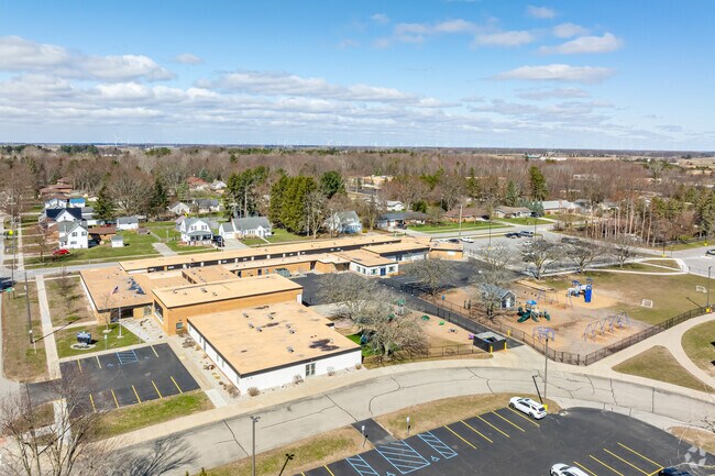 Hemlock Elementary School features a large play area behind the school for student recess.