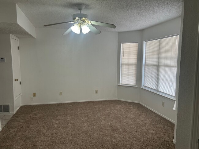 Living room with ceiling fan new carpet and paint