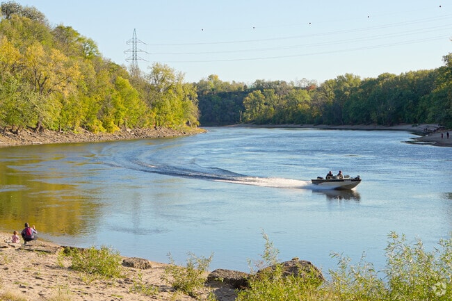 A boat makes its way down the Mississippi River in Hidden Falls Park.
