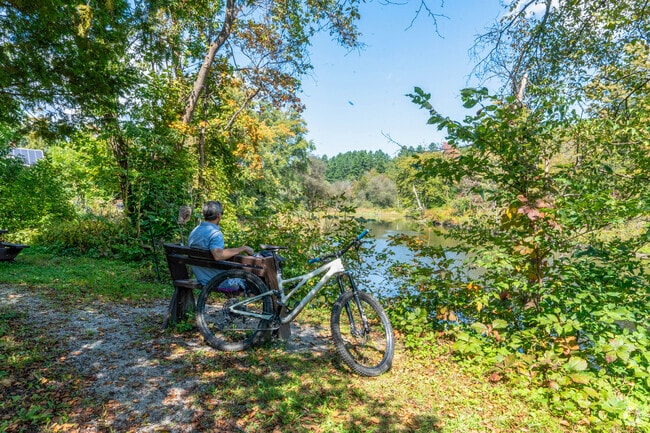 A man enjoys his lunch break in Mill Pond Park overlooking the Winooski River in The Meadow.