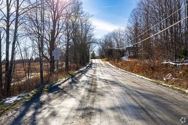 A quiet country road winds through Westford, offering peaceful views of open fields, bare winter trees, and classic rural Vermont scenery.