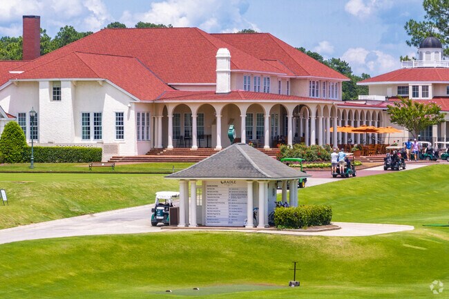 Golf carts cruise beside the iconic clubhouse at Pinehurst’s Cradle course.