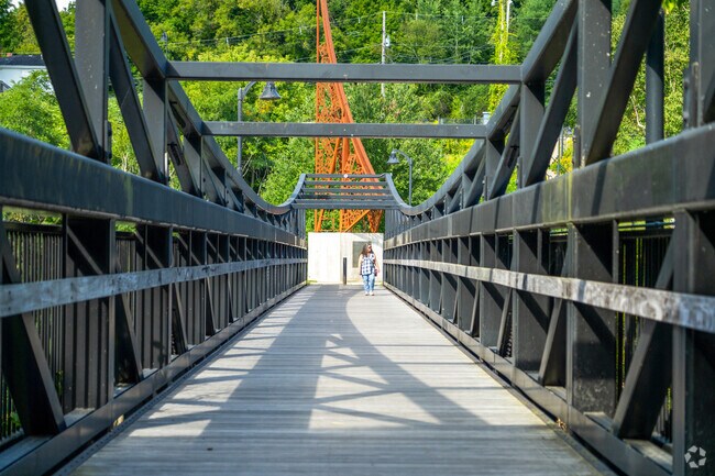 A person walks down a footbridge above the Sugar River near Washington Street District.