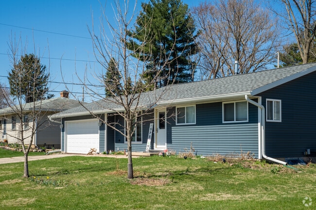 A blue ranch-style house on a quiet residential street in the Burr Oaks Neighborhood.