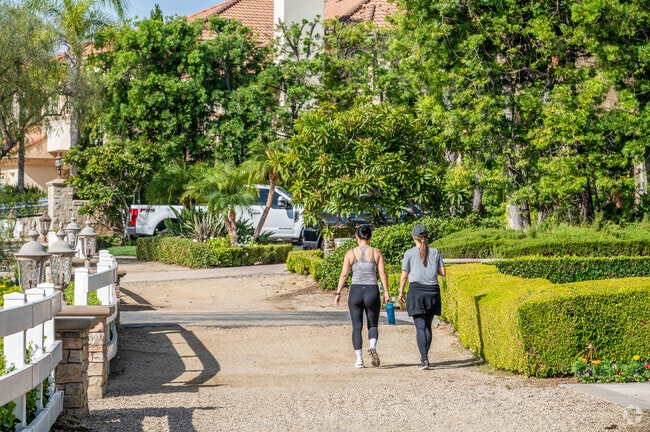 Raymond Hills residents enjoy a walk on wide trails with lush landscaping.