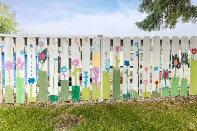 Painted by younger students colorful fence surrounding an outdoor play area.